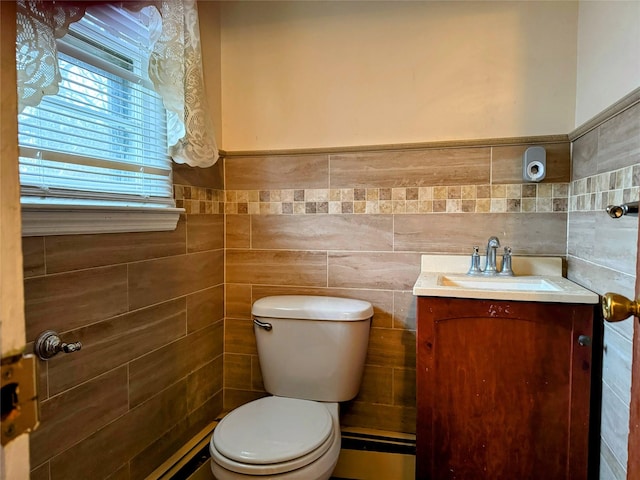 bathroom with vanity, toilet, and tile walls