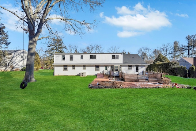 rear view of house featuring a lawn and a deck