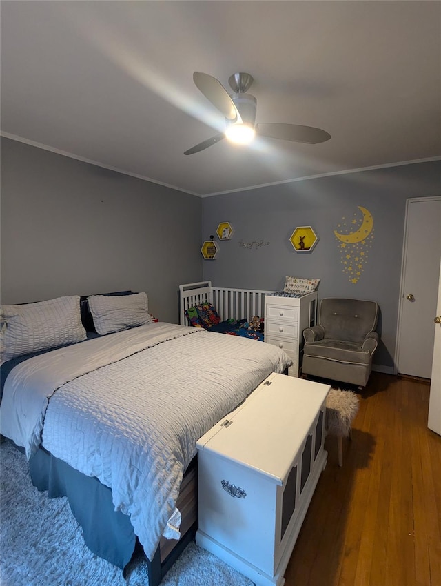 bedroom with crown molding, wood-type flooring, and ceiling fan