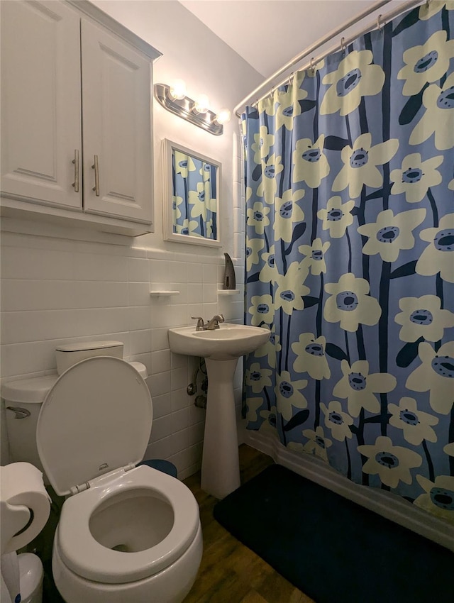 bathroom with hardwood / wood-style floors, toilet, tile walls, and a shower with curtain