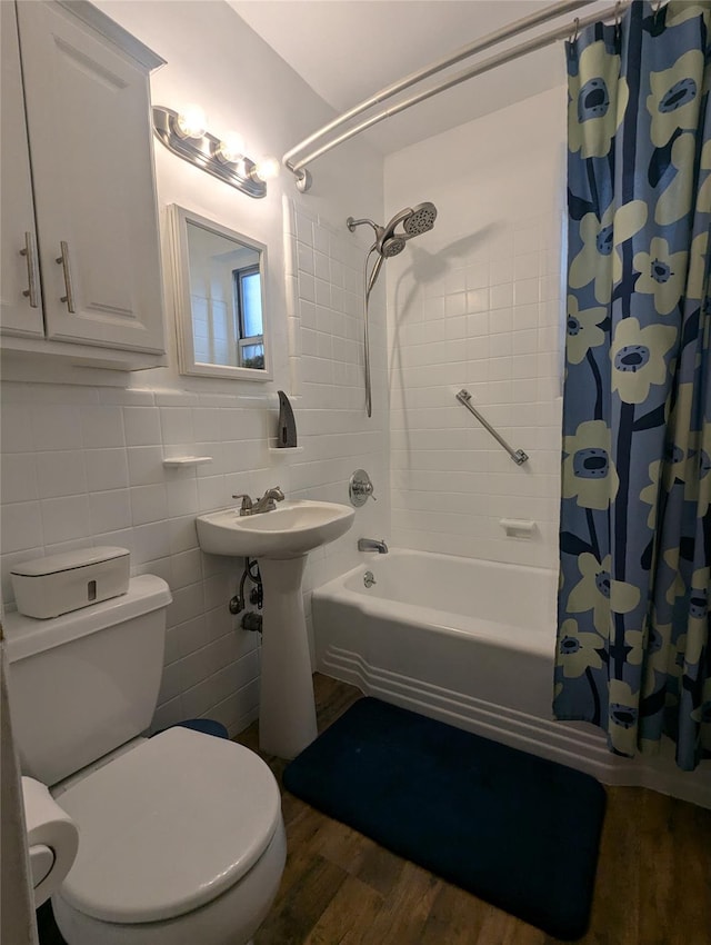 full bathroom featuring wood-type flooring, sink, tile walls, shower / bath combination with curtain, and toilet