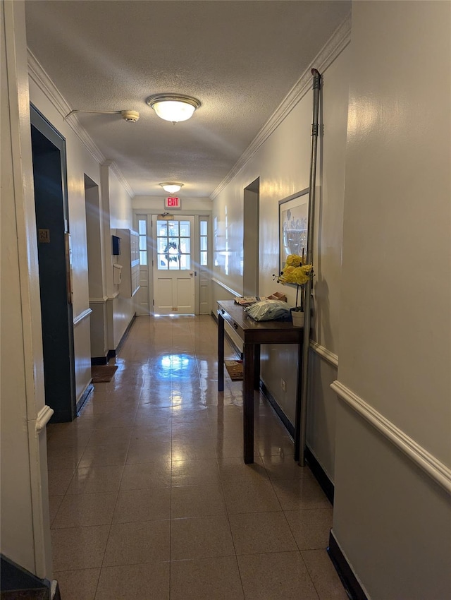 corridor featuring tile patterned flooring, ornamental molding, and a textured ceiling