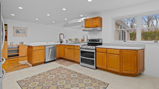 kitchen featuring sink, kitchen peninsula, extractor fan, light tile patterned floors, and appliances with stainless steel finishes