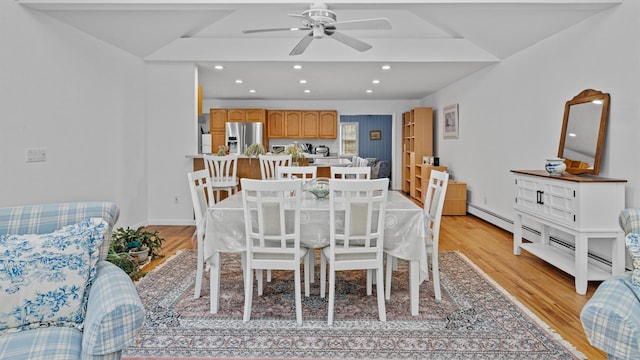 dining space with light wood-type flooring, vaulted ceiling, and ceiling fan