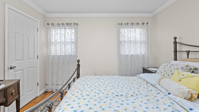 bedroom featuring hardwood / wood-style floors, crown molding, and multiple windows