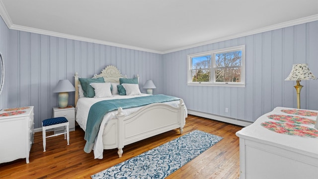 bedroom featuring hardwood / wood-style floors, crown molding, and a baseboard radiator