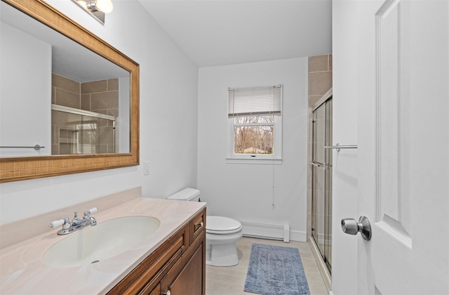 bathroom with vanity, tile patterned floors, toilet, baseboard heating, and a shower with shower door