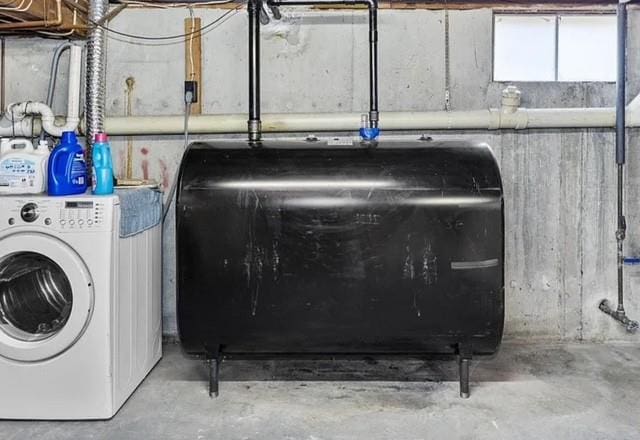 washroom featuring laundry area, washer / dryer, and heating fuel