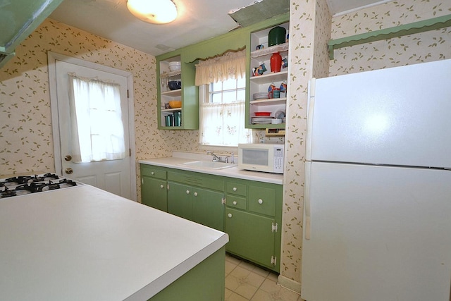 kitchen with a healthy amount of sunlight, green cabinets, white appliances, and sink