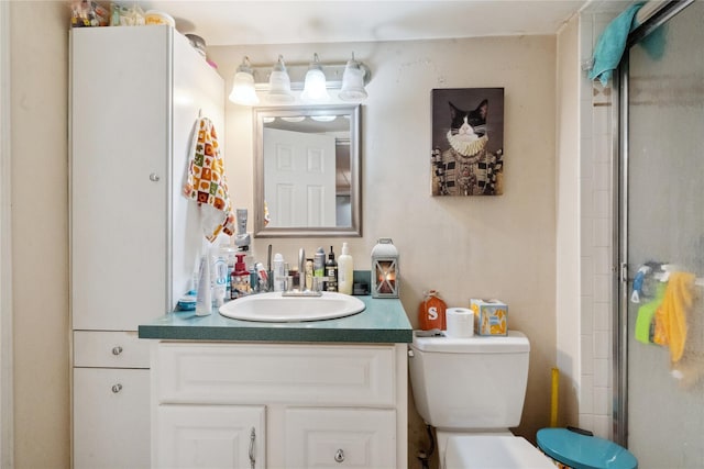 bathroom featuring vanity, toilet, and a shower with shower door