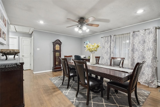 dining space with wood-type flooring, ceiling fan, and crown molding