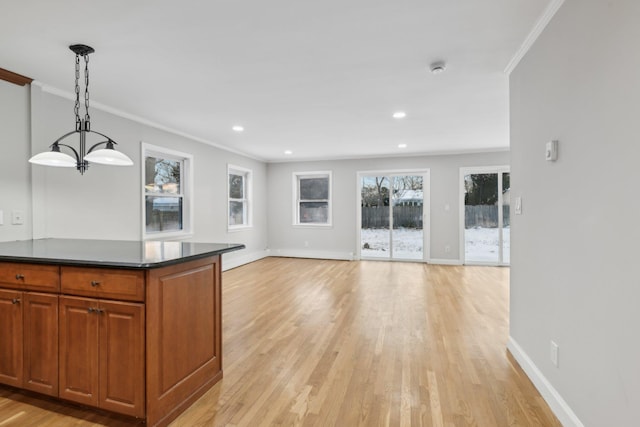 kitchen with decorative light fixtures, ornamental molding, and light hardwood / wood-style floors