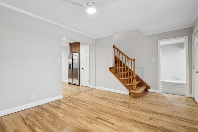 spare room featuring crown molding and light wood-type flooring