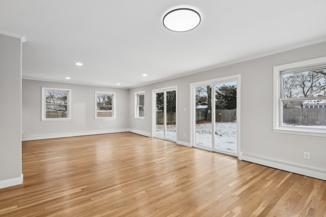 unfurnished living room with baseboard heating, crown molding, and light hardwood / wood-style flooring