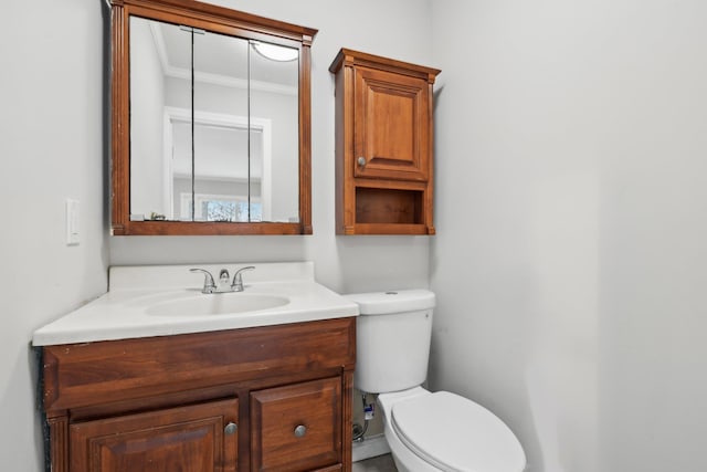 bathroom with vanity, crown molding, and toilet