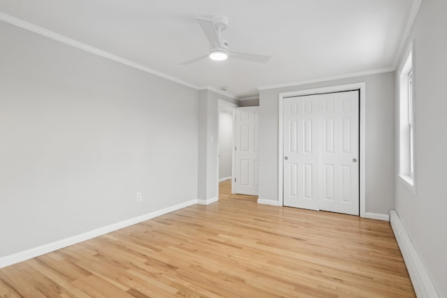 unfurnished bedroom with ceiling fan, ornamental molding, a closet, and a baseboard heating unit