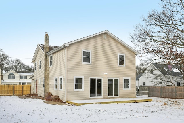 view of snow covered back of property