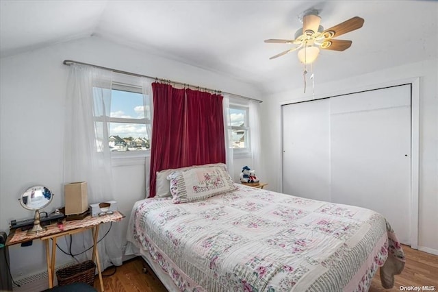 bedroom with ceiling fan, a closet, vaulted ceiling, and hardwood / wood-style flooring