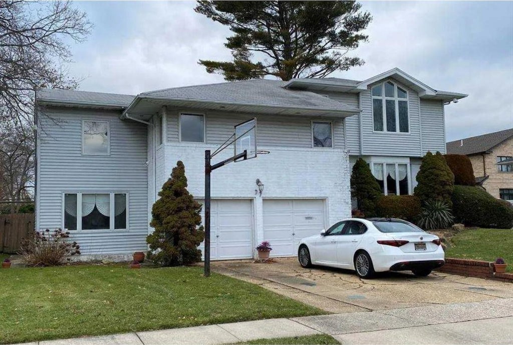 view of front of house with a garage and a front lawn