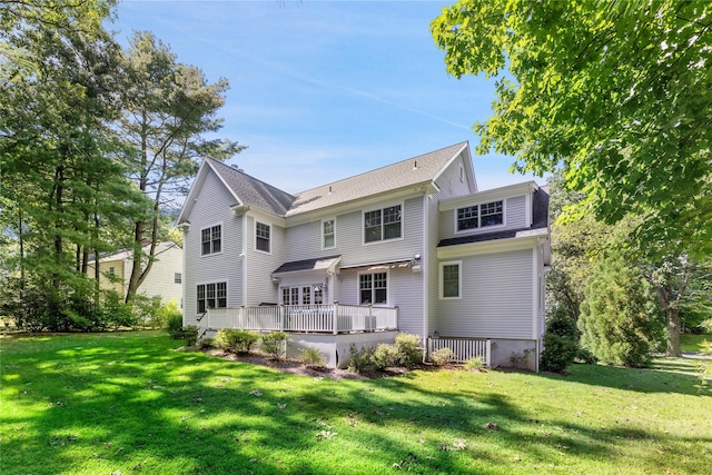 rear view of house with a deck and a yard