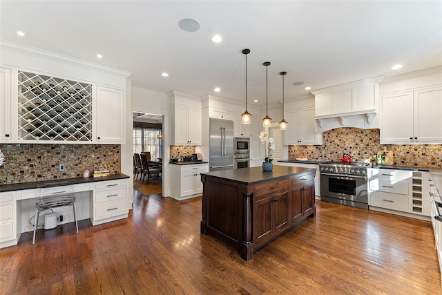 kitchen featuring dark wood-type flooring, a kitchen island, pendant lighting, and built in appliances