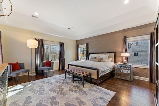 bedroom featuring a raised ceiling and dark hardwood / wood-style floors