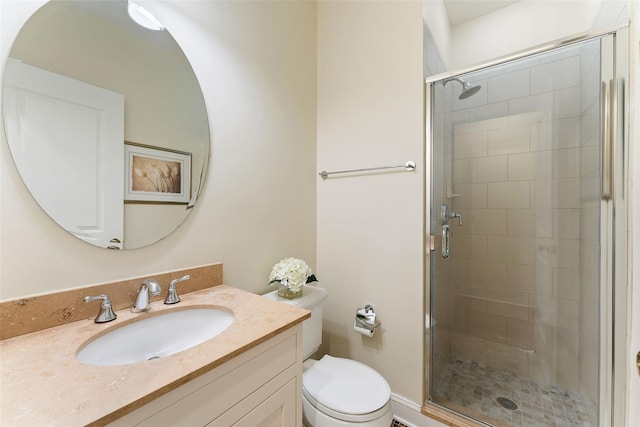 bathroom with toilet, vanity, and an enclosed shower