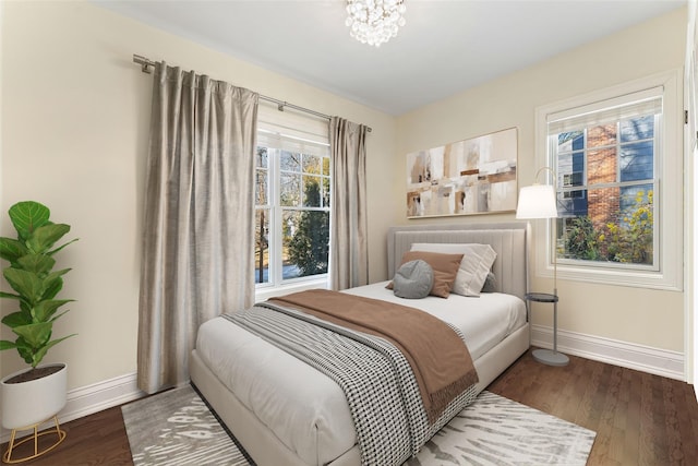 bedroom with dark wood-type flooring and a notable chandelier