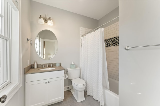 full bathroom featuring toilet, shower / bath combination with curtain, and vanity