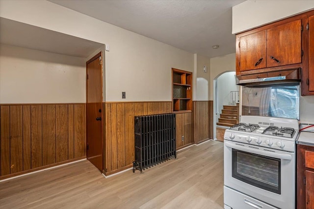 kitchen with white range with gas stovetop and light hardwood / wood-style floors