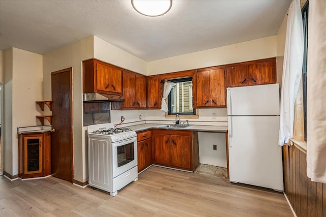 kitchen with white appliances, ventilation hood, light hardwood / wood-style flooring, and sink