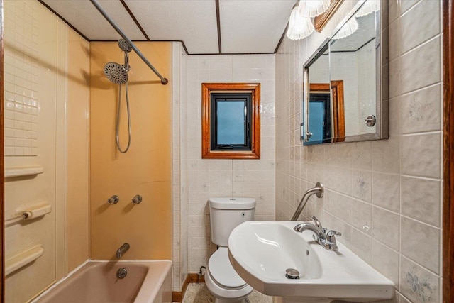 full bathroom featuring shower / bath combination, toilet, tile walls, and sink