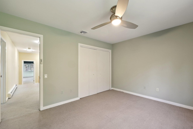 unfurnished bedroom with ceiling fan, a closet, light carpet, and a baseboard heating unit