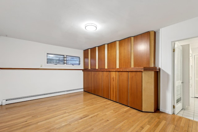 interior space with light hardwood / wood-style flooring and a baseboard heating unit