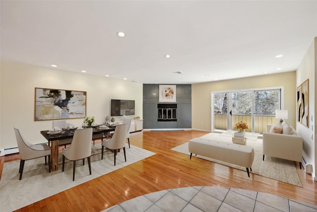 4 Dakota Ct, Suffern, NY 10901 - living room with baseboard heating, a glass covered fireplace, recessed lighting, and light wood-style floors