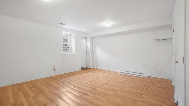 2413 Wilson Ave, Bronx, NY 10469 - spare room featuring light wood-type flooring and a baseboard heating unit