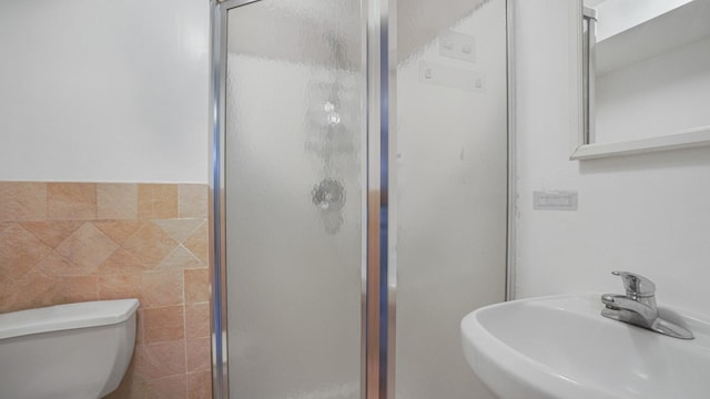 2413 Wilson Ave, Bronx, NY 10469 - bathroom featuring toilet, tile walls, a shower with shower door, and sink