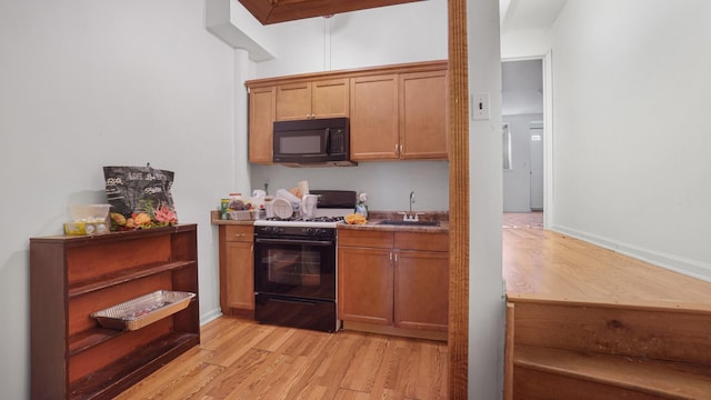 2413 Wilson Ave, Bronx, NY 10469 - kitchen featuring black appliances, light wood-type flooring, and sink
