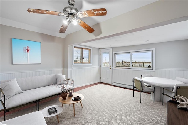 living room with ceiling fan and a baseboard heating unit