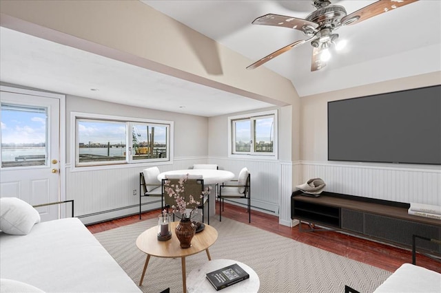 living room with baseboard heating, a healthy amount of sunlight, lofted ceiling, and hardwood / wood-style flooring