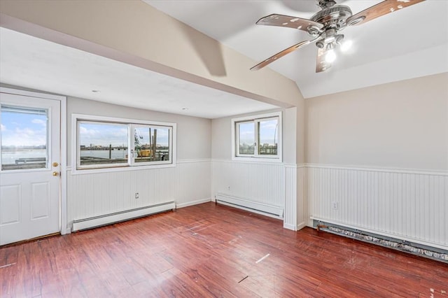 empty room featuring lofted ceiling, a wealth of natural light, and a baseboard radiator