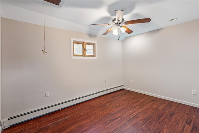 empty room with ceiling fan, dark hardwood / wood-style flooring, and a baseboard heating unit