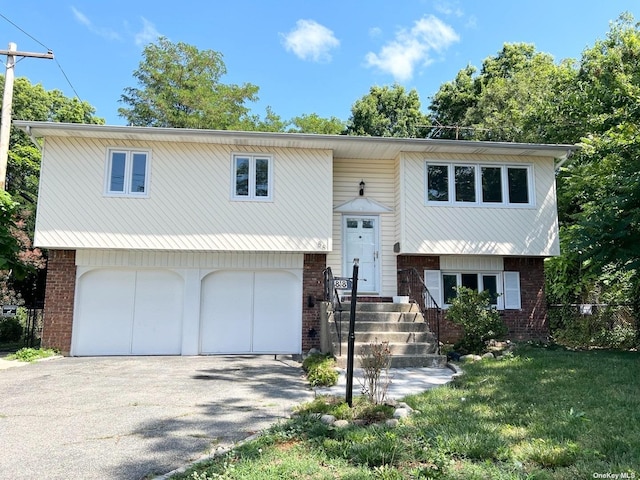 split foyer home featuring a front yard and a garage