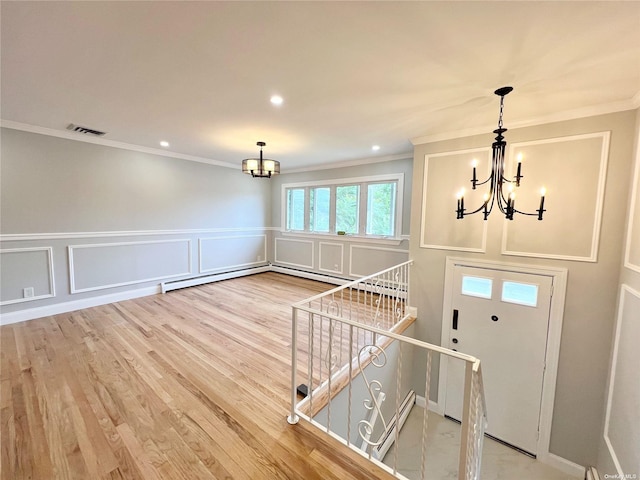 foyer featuring hardwood / wood-style flooring, crown molding, and an inviting chandelier