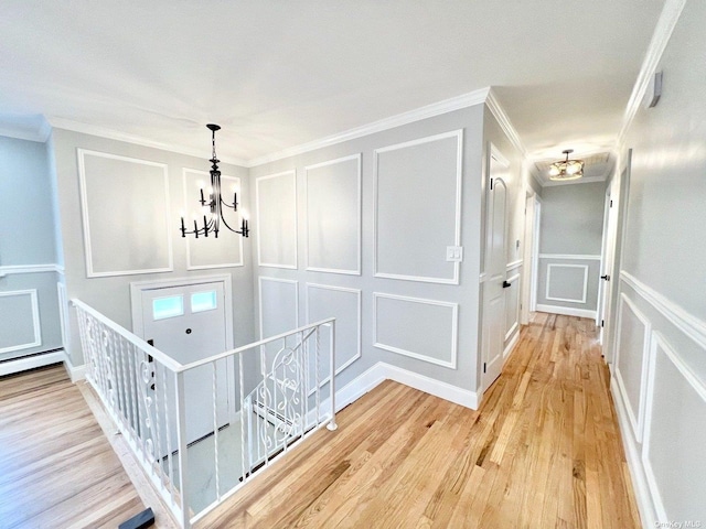 hallway featuring crown molding, hardwood / wood-style floors, and a notable chandelier