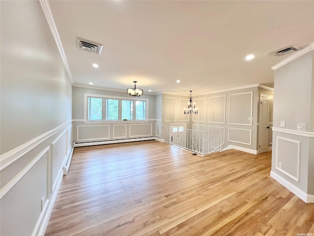 empty room featuring light hardwood / wood-style flooring, baseboard heating, crown molding, and an inviting chandelier