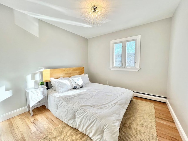 bedroom with light hardwood / wood-style flooring and a baseboard radiator