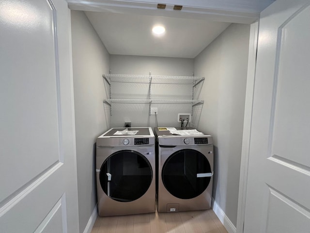 laundry area featuring light wood-type flooring and independent washer and dryer