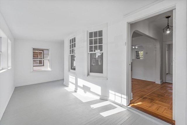 unfurnished room featuring plenty of natural light and parquet floors