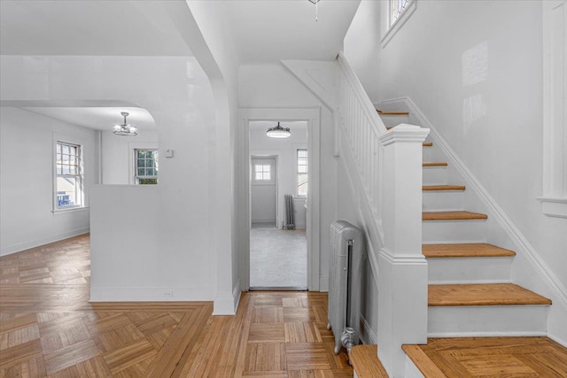 staircase featuring parquet flooring and radiator